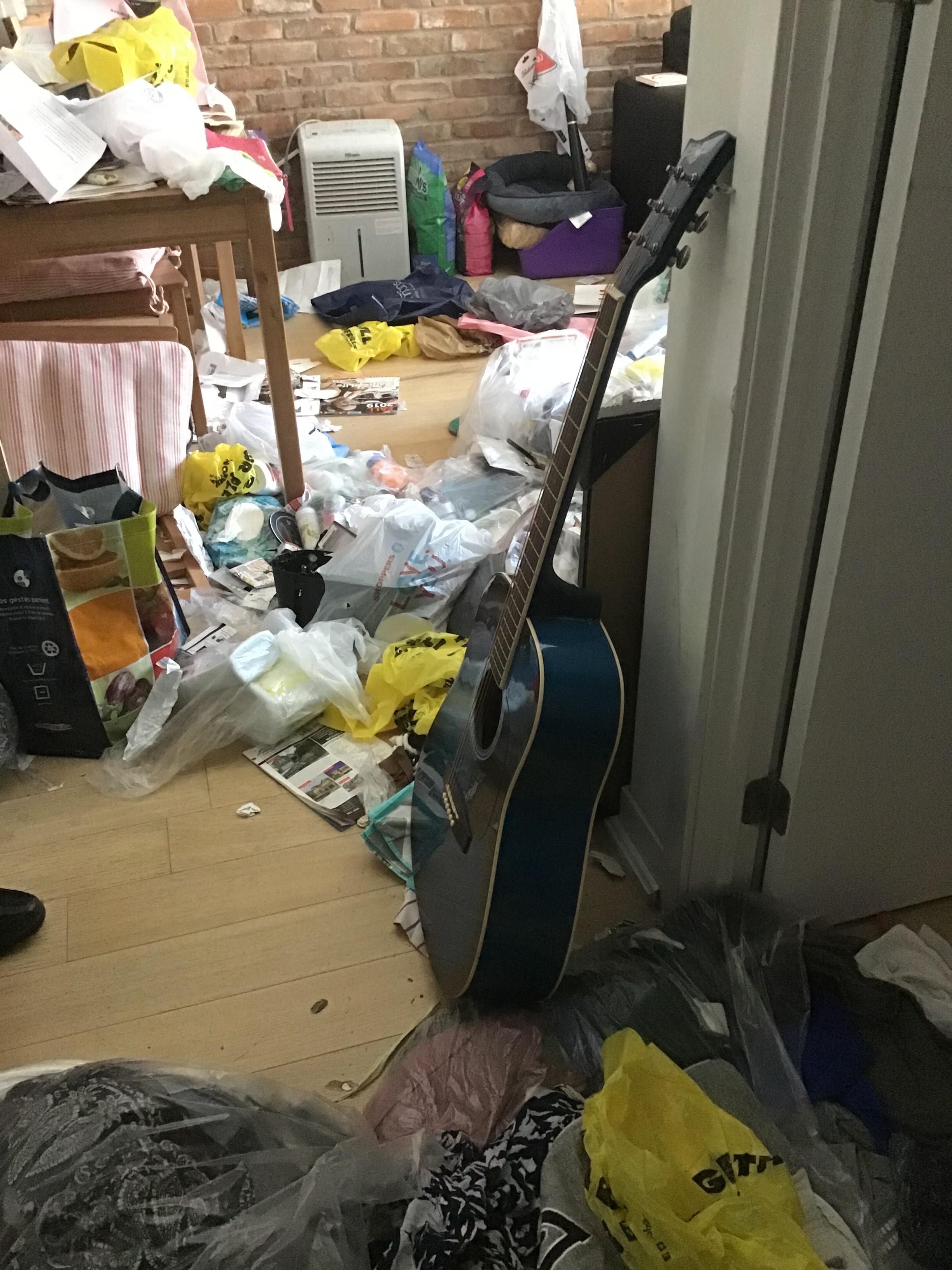 Cluttered bedroom floor with scattered belongings
