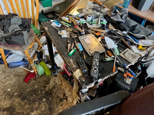 Cluttered room with scattered household items throughout
